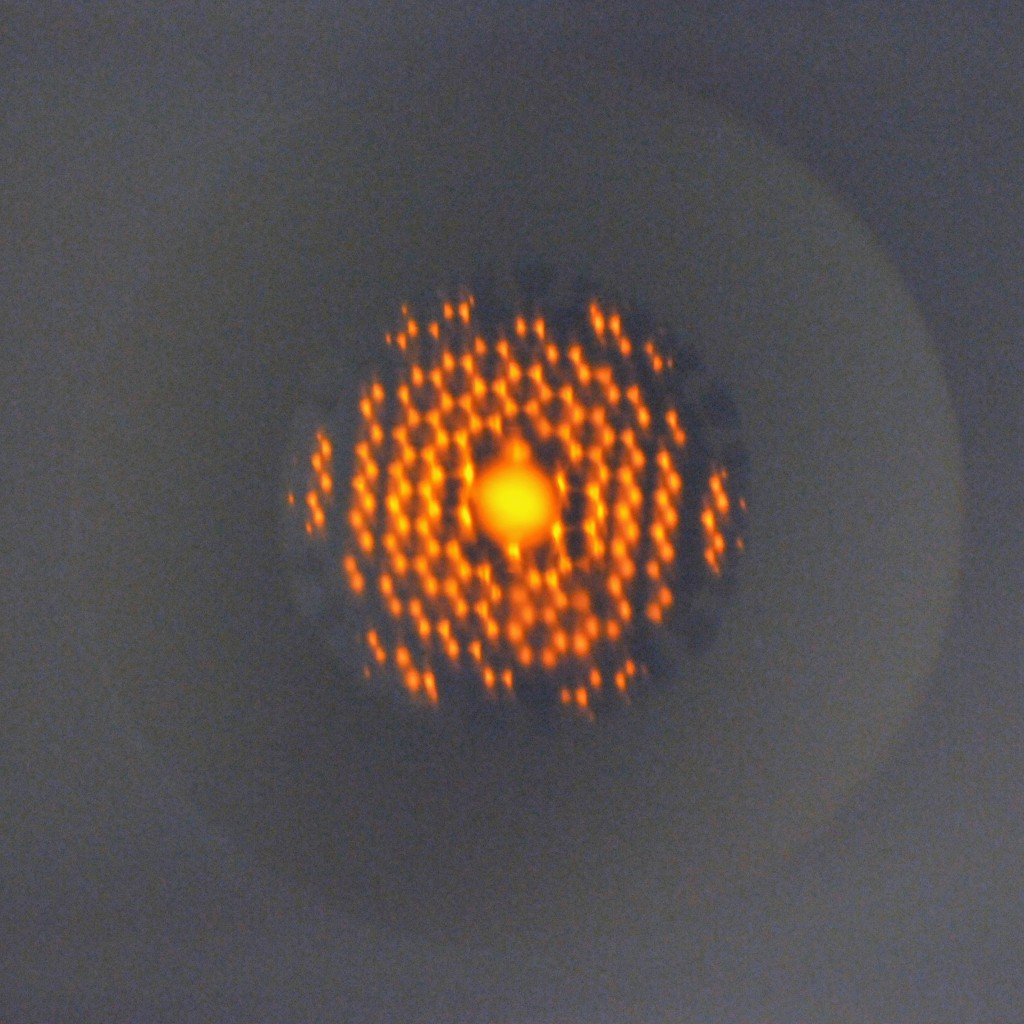 Orange light guided through air by the first successful lawrence livermore hollow-core optical fiber.