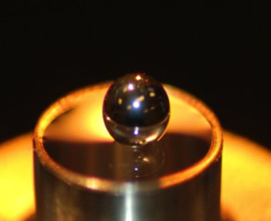 Figure 1. a 15-nm film of formvar polymer stretched across a 5-mm hoop supports a steel ball that weighs 30 mg, more than 80,000 times the mass of the polymer film.